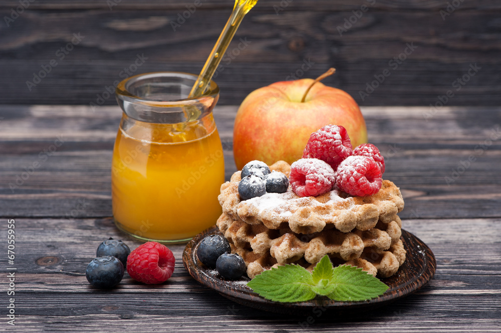 Waffles with raspberries, blueberries, fruit and honey. Waffles with raspberries, blueberries, fruit and honey.