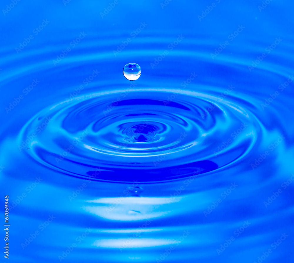 water droplets falling in blue water water droplets falling in blue water