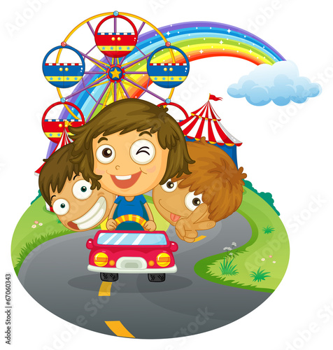 A vehicle with happy kids near the amusement park