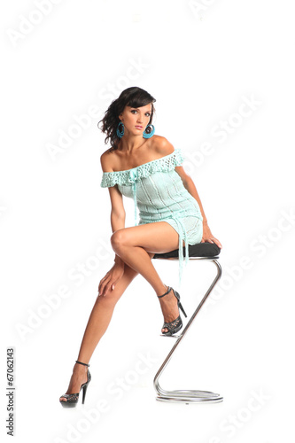 Sexy brunette woman wearing short dress sit on stool
