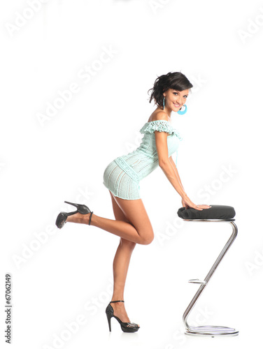 Woman supported by a stool kicking up one of her feet