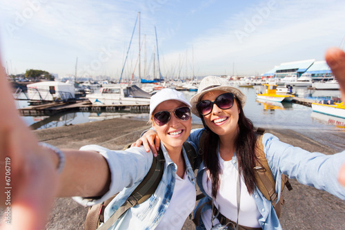 Fotografia two travellers taking selfie by the harbor