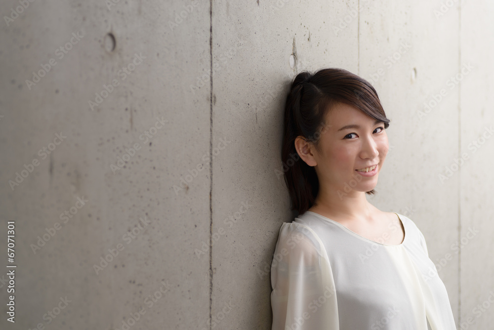 コンクリートの壁に寄りかかる女性 Stock 写真 Adobe Stock