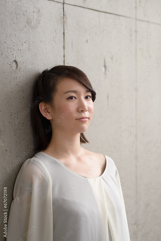 コンクリートの壁に寄りかかる女性 コンクリートの壁に寄りかかる女性
