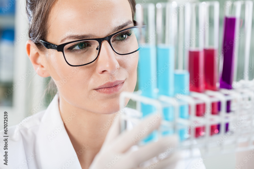 Woman looking at test tubes Woman looking at test tubes