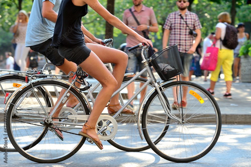 Summer couple on bikes in green city - obrazy, fototapety, plakaty 