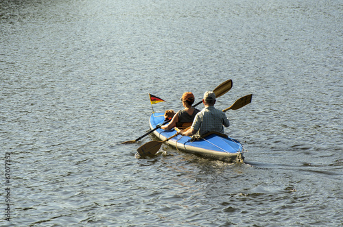 Mann, Frau und Hund von hinten im Ruderboot bei Gegenlicht