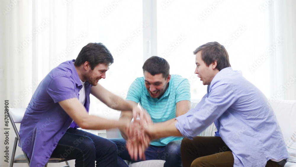 smiling male friends with hands together at home smiling male friends with hands together at home