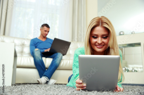 Young couple relaxing at home with electronic equipment