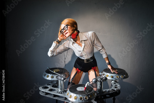 DJ girl in sexy outfit playing on vinyl