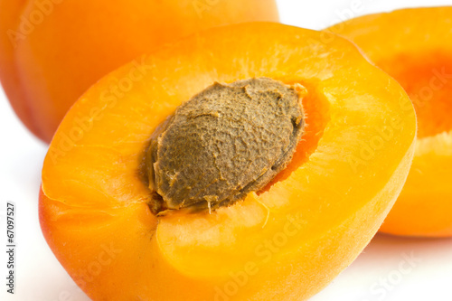 Detail of a ripe apricot cut open with stone visible.