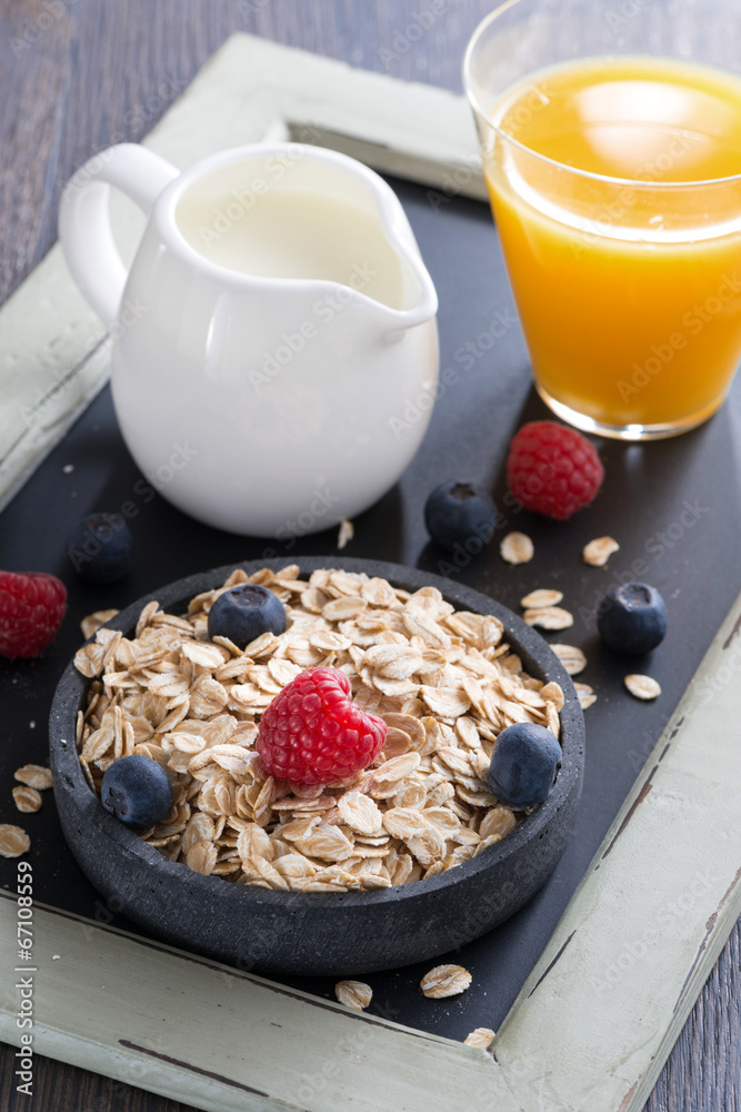 cereal, fresh berries, milk and orange juice, close-up