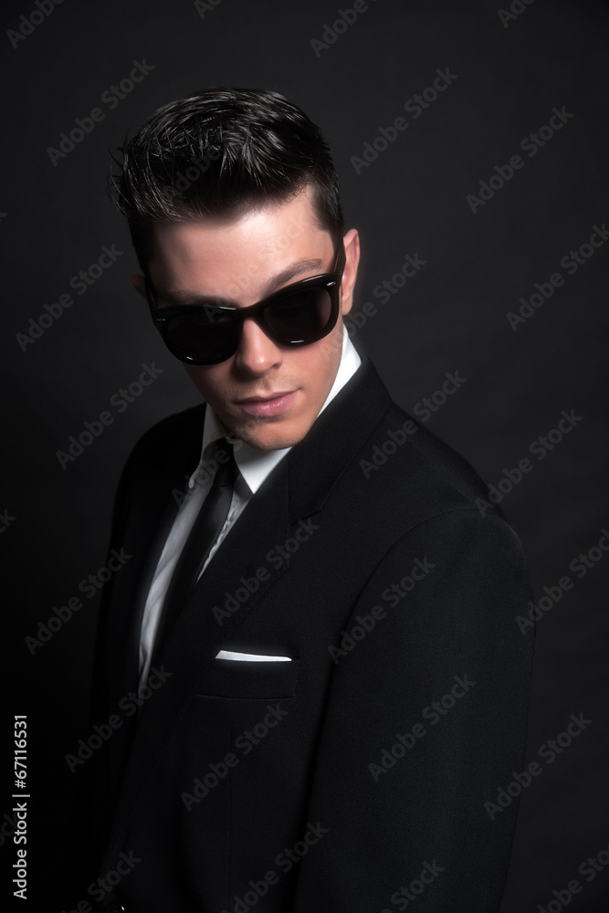 Obraz premium Retro fifties fashion man wearing black sunglasses with suit and