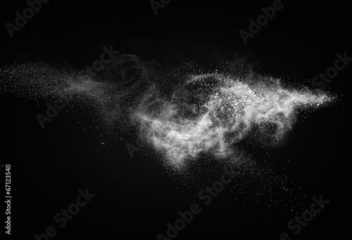 White powder exploding isolated on black