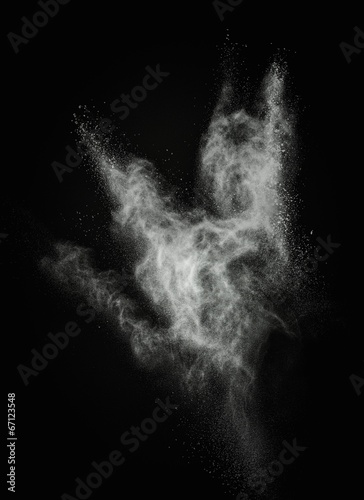 White powder exploding isolated on black