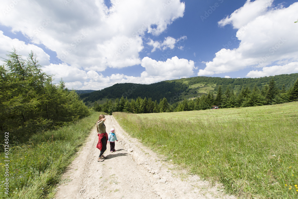 Woman with child hikes mountain patch, Gorce Mountains, Poland