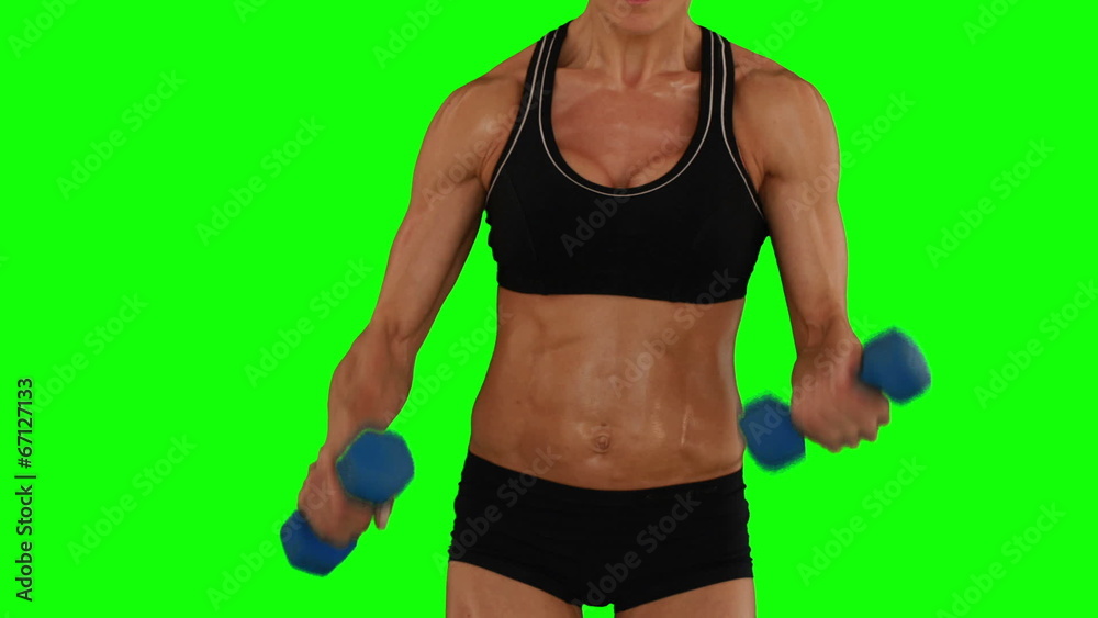 Super fit woman lifting dumbbells in black sports bra and shorts Super fit woman lifting dumbbells in black sports bra and shorts
