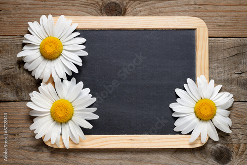 Fototapeta Naklejka Na Ścianę i Meble -  Daisy flowers and blackboard on wooden background