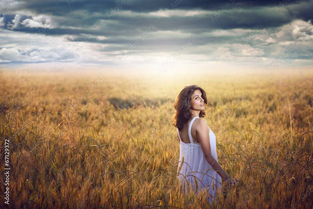 Beautiful woman in corn field with dramatic light