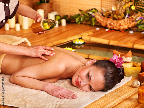 Woman getting massage in bamboo spa.