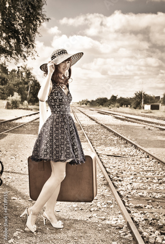 Beautiful woman with suitcase on a train station. photo