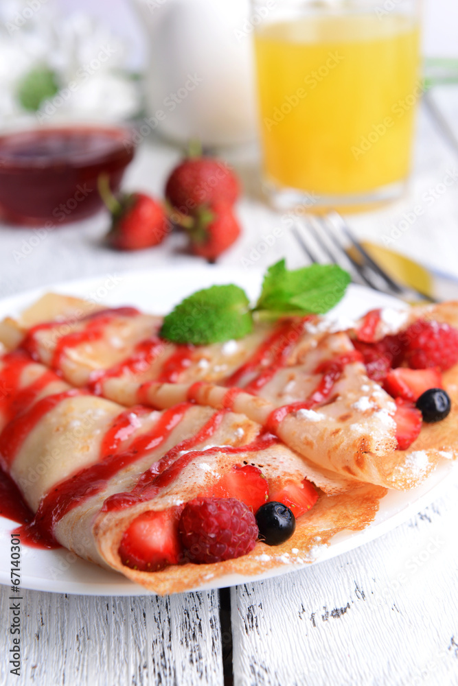Delicious pancakes with berries on table close-up