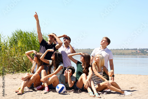 Group of friends with ball at beach