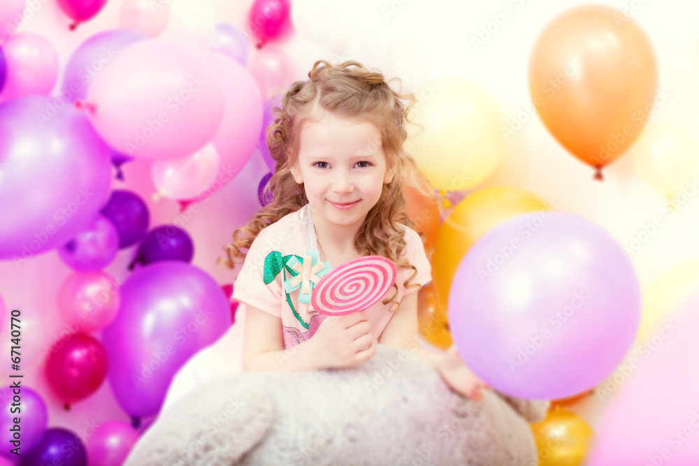 Obraz premium Adorable curly girl posing on balloons backdrop