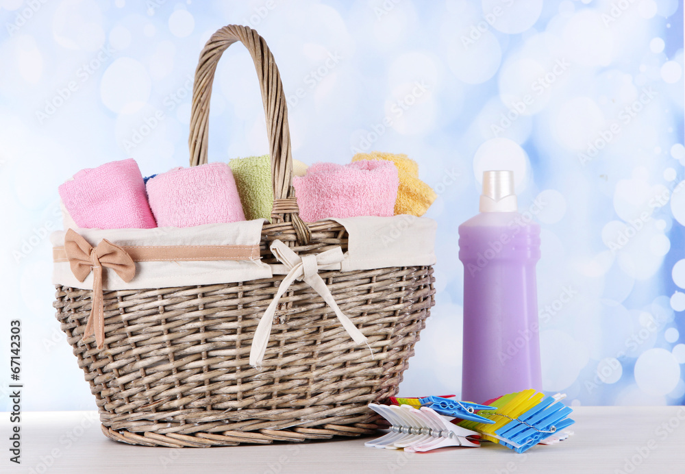Colorful towels in basket, on table, on bright background Colorful towels in basket, on table, on bright background