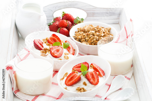 healthy breakfast - yogurt, strawberries, granola and milk
