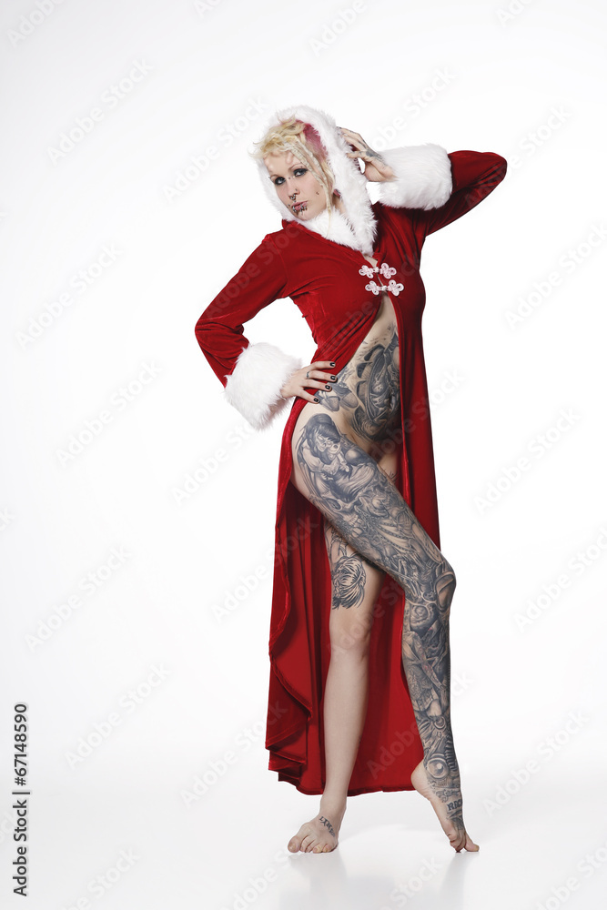 tätowierte junge Frau im Weihnachtskostüm roter Mantel