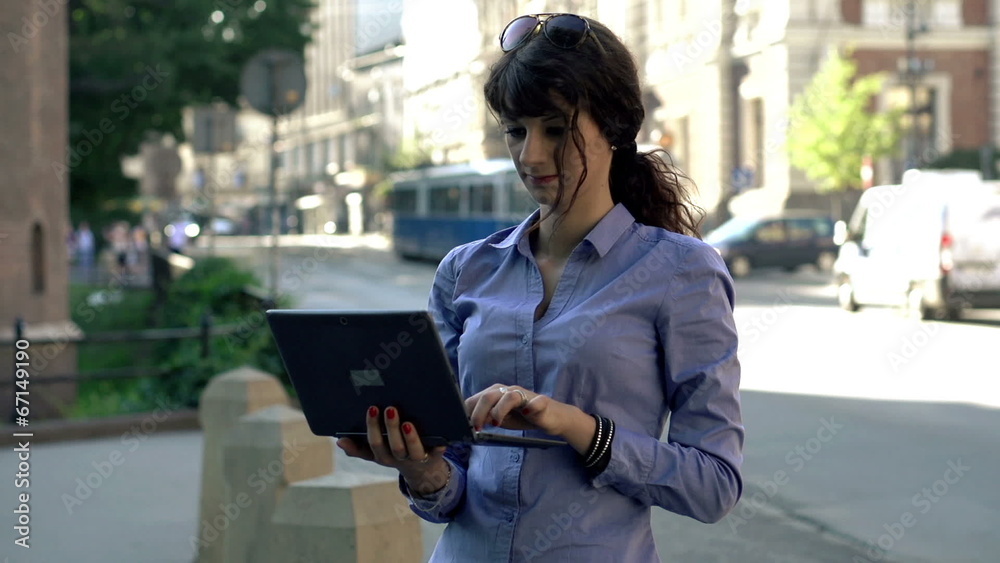 Young businesswoman working on laptop computer by the street Young businesswoman working on laptop computer by the street