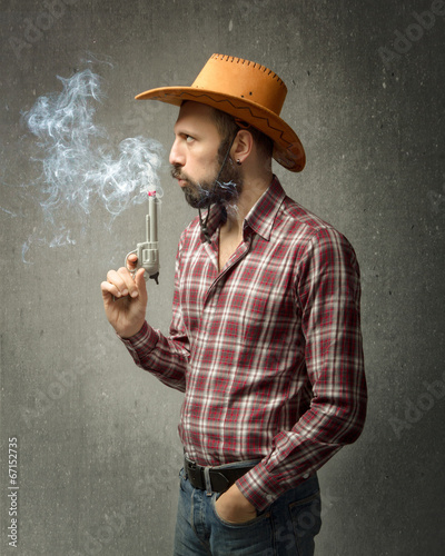 cow boy blows on gun