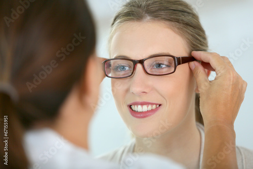 Fototapeta Naklejka Na Ścianę i Meble -  Woman trying new eyeglasses with ophtalmologist