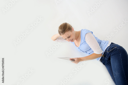 Young woman laying on floor with tablet, isolated