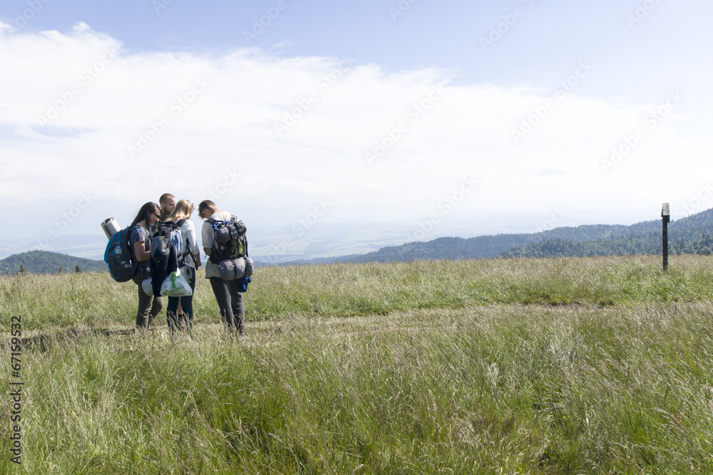 A group of friends on mountain path, Gorce Mountains, Poland A group of friends on mountain path, Gorce Mountains, Poland