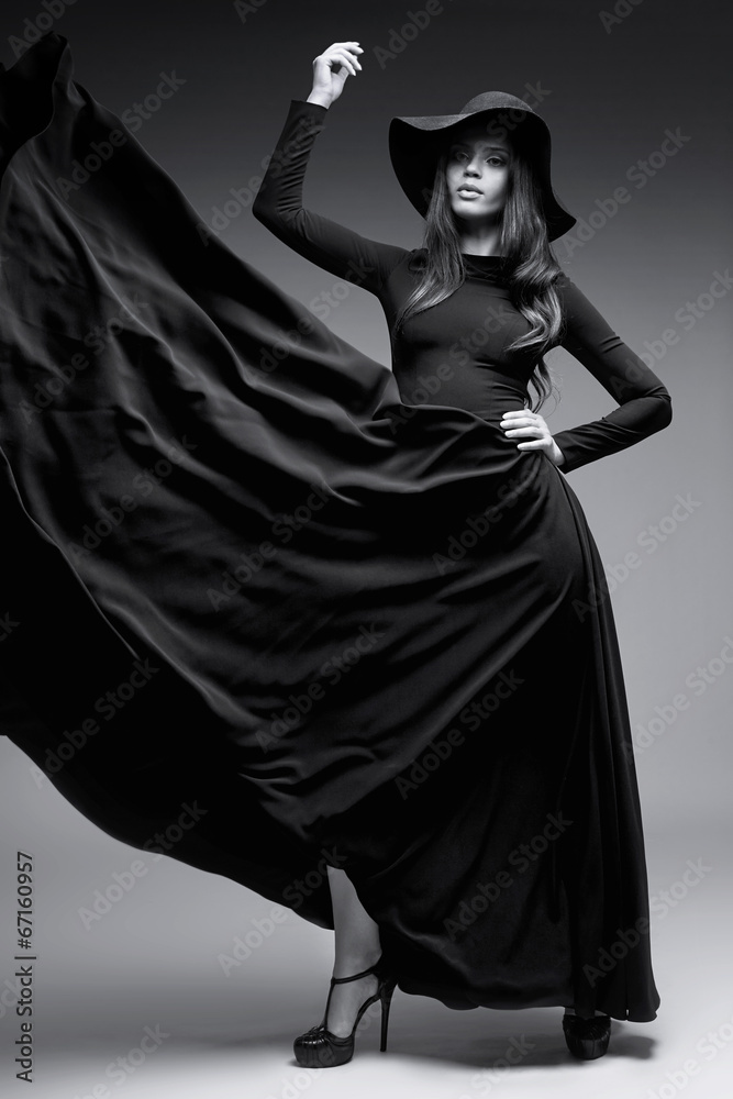 Elegant woman in a hat and long fluttering dress Elegant woman in a hat and long fluttering dress
