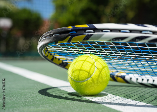 Close up view of tennis racket and balls on  tennis court © gawriloff
