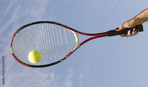 Tennis racquet and ball against blue sky © petert2
