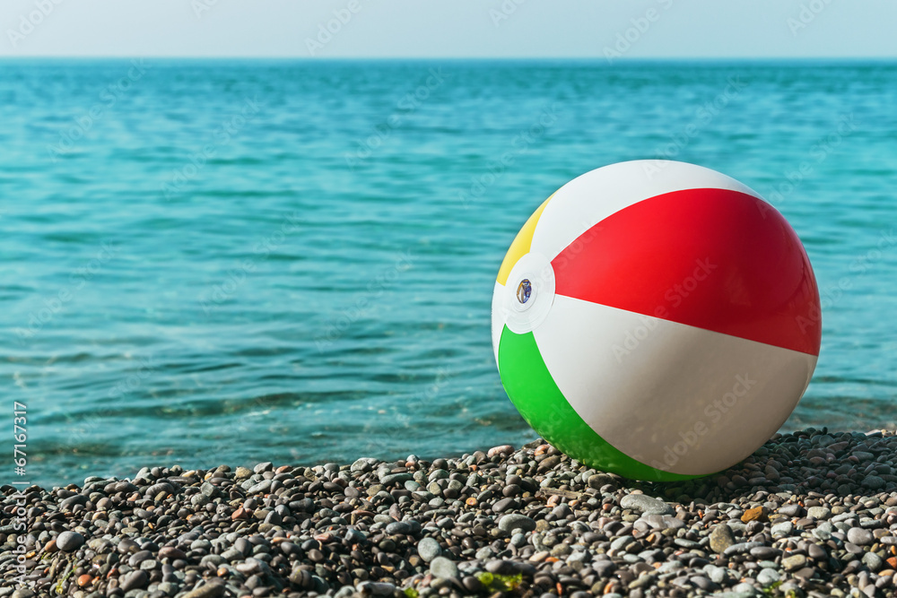 children's ball on the beach against the sea