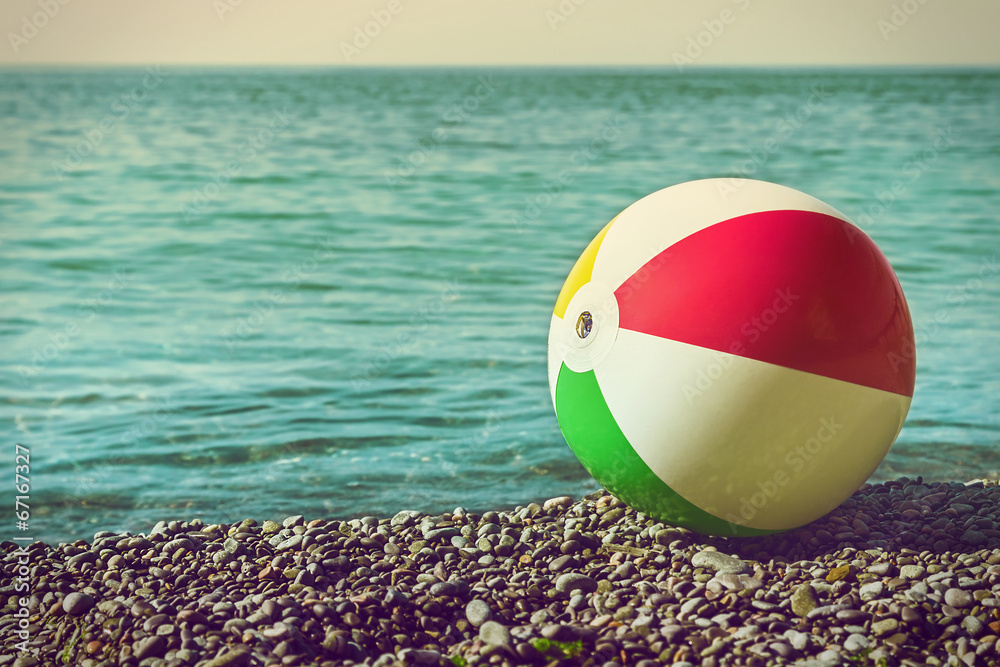 children's ball on the beach against the sea