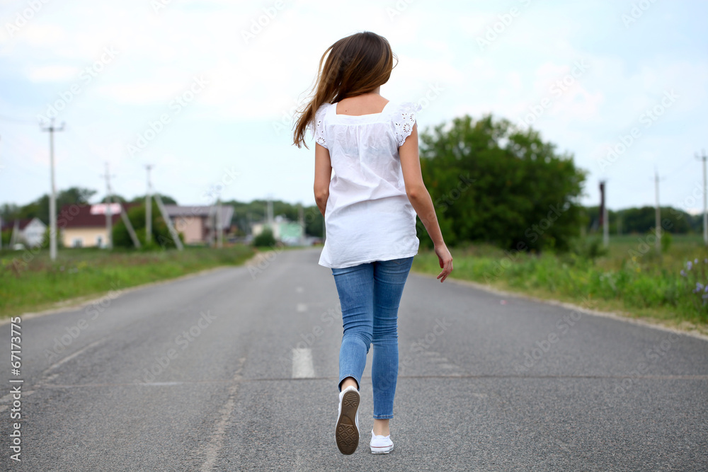 Young woman running along a country road Young woman running along a country road