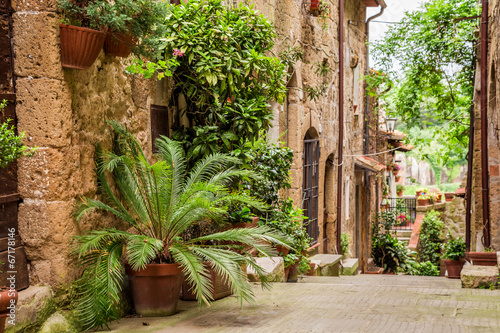 Fototapeta Naklejka Na Ścianę i Meble -  Tuscan Street in the city full of flowery porches