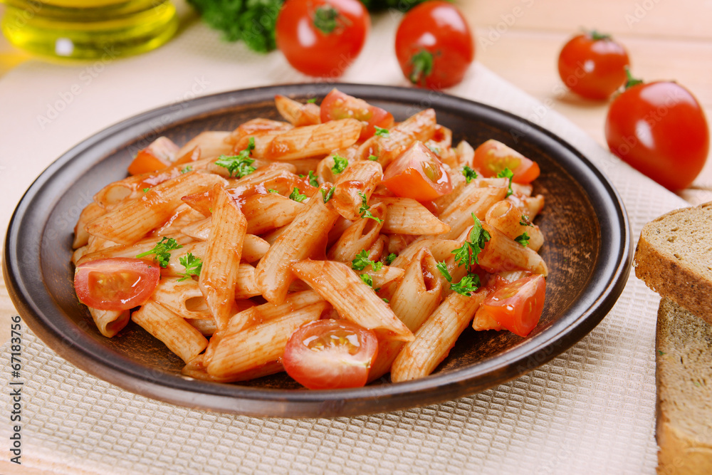 Pasta with tomato sauce on plate on table close-up