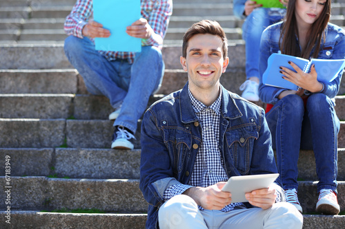 Happy students sitting on s...