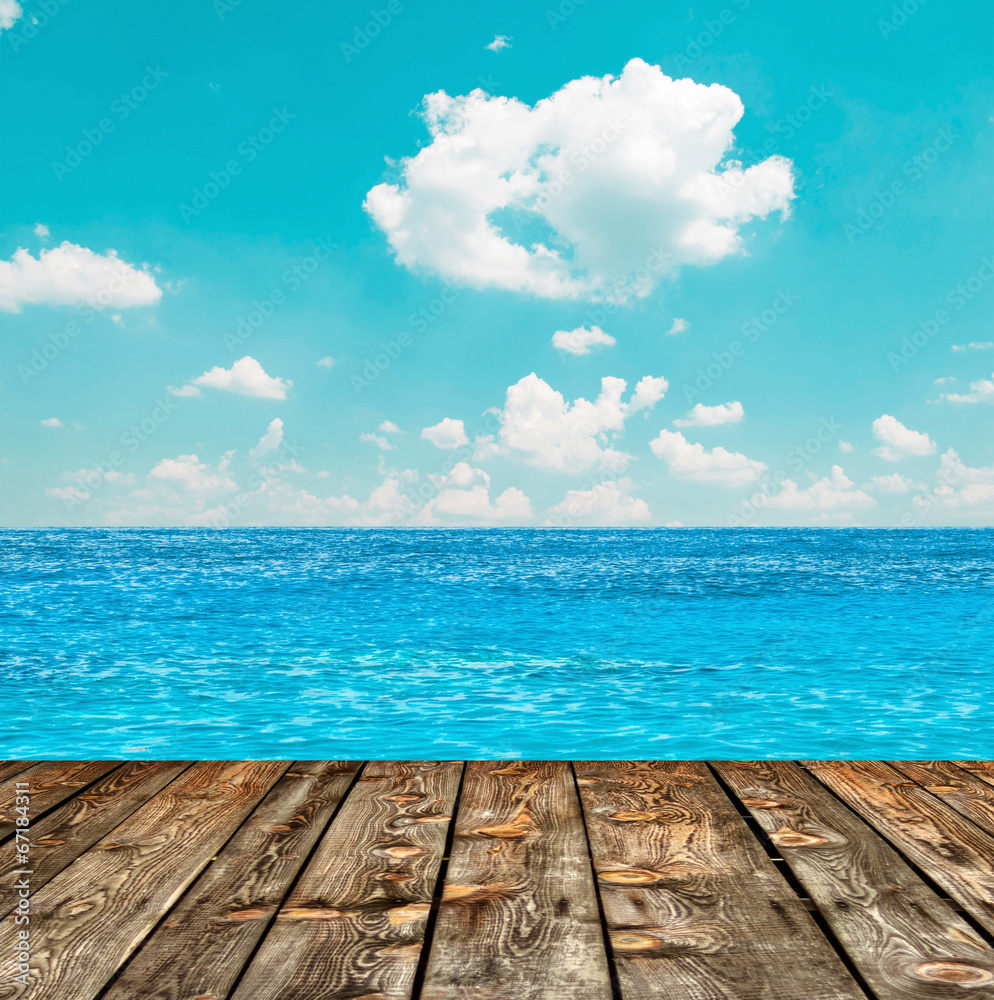 Blue ocean and sky above wooden floor