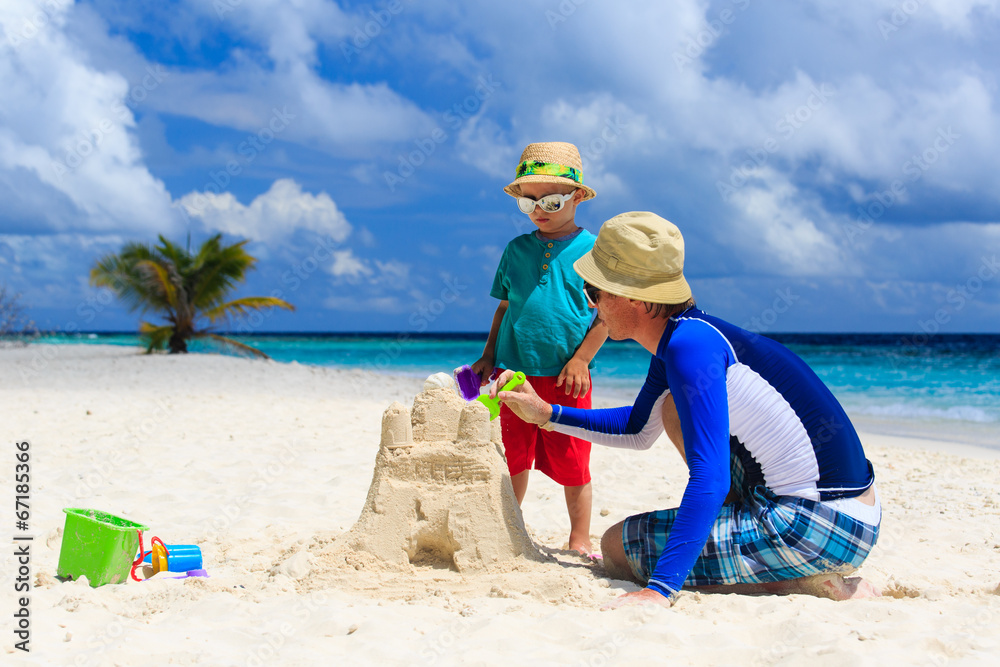 father and son building castle on the beach father and son building castle on the beach