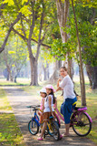 Asian child with mother on bike, active family concept