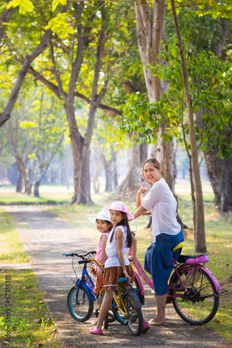 Asian child with mother on bike, active family concept
