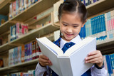 Asian little student in library